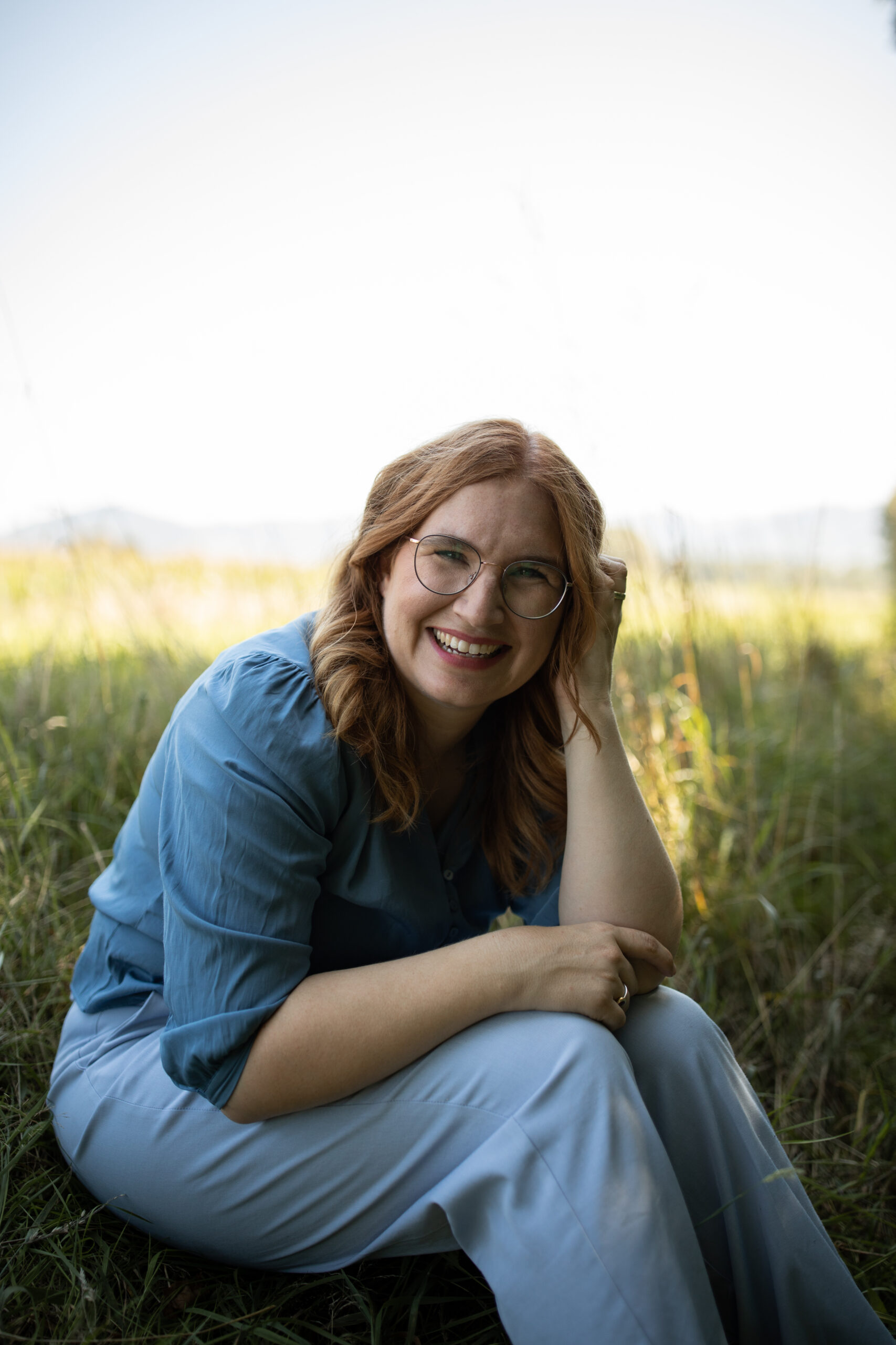 Dieses Foto zeigt die Autorin Nora Imlau lachend im Gras.
